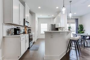 a kitchen with white cabinets and a table and chairs at 2022 quiet relaxing and secure town house near Atlanta in Redan