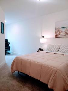 a bedroom with a large bed in a white room at 2022 quiet relaxing and secure town house near Atlanta in Redan
