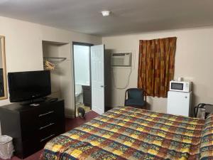 une chambre d'hôtel avec un lit et une télévision dans l'établissement Pennswoods Inn, à Manheim