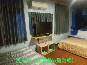 een slaapkamer met een bed en een tv in een kamer bij Yung Feng Hotel in Keelung