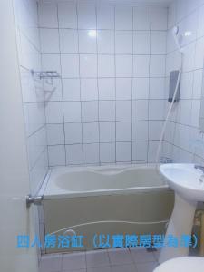 基隆的住宿－永豐旅社，白色瓷砖浴室设有浴缸和水槽
