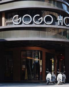 duas scooters estacionadas em frente a um edifício do Google em Gogo Hotel em Taichung