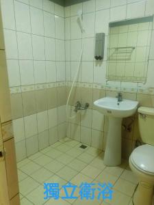 een badkamer met een douche, een wastafel en een toilet bij Yung Feng Hotel in Keelung