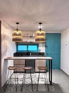 eine Küche mit zwei Hockern und einer Theke mit zwei Leuchten in der Unterkunft Parallelo Loft Salento P1 in Salento
