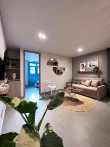 ein Wohnzimmer mit einem Sofa und einer Pflanze in der Unterkunft Parallelo Loft Salento P1 in Salento
