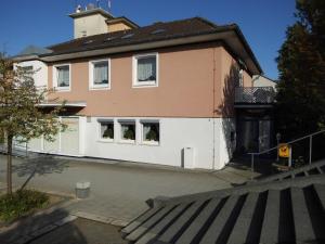 a house with a white fence and a building at Hotel Garni am Heuberg in Eschwege