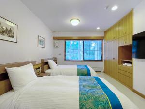 a hotel room with two beds and a tv at 舜山荘-元箱根 貸切別荘-最大人数9名 in Moto-hakone