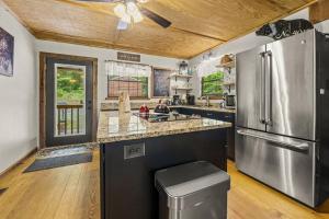 a large kitchen with a stainless steel refrigerator at Wears Valley Cabin on 5 Acres, Hot Tub, Pets in Sevierville