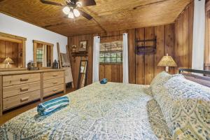 a bedroom with a large bed and wooden walls at Wears Valley Cabin on 5 Acres, Hot Tub, Pets in Sevierville
