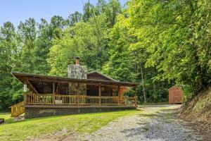a log cabin in the middle of a forest at Wears Valley Cabin on 5 Acres, Hot Tub, Pets in Sevierville