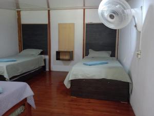 Habitación pequeña con 2 camas y ventilador. en APARTAMENTOS CINKEM, en La Loma