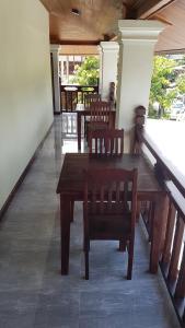 a wooden table and chairs in a room at Villa KhounSok Sunset in Luang Prabang