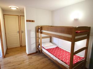 Łóżko piętrowe w niewielkim pokoju z drzwiami w obiekcie Appartement Chamrousse, 3 pièces, 6 personnes - FR-1-549-127 w mieście Chamrousse