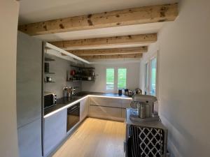 a kitchen with white walls and wooden ceilings at Chalet pour 10 pers. avec cheminée et bain norvégien - FR-1-733-70 in Crest-Voland
