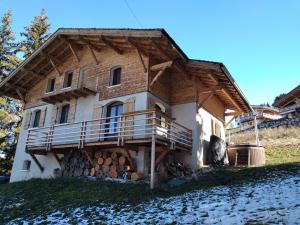 a house with a deck on the side of it at Chalet pour 10 pers. avec cheminée et bain norvégien - FR-1-733-70 in Crest-Voland