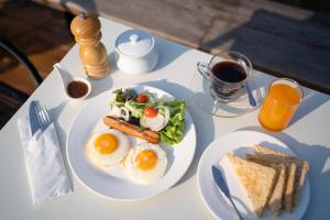 a white table topped with a plate of eggs and toast at CLIFF VERANDAH @ DOI LAN in Ban Huai Khai