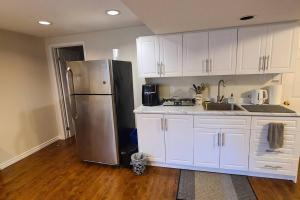 una cucina con armadi bianchi e frigorifero in acciaio inossidabile di Spacious and bright unit with natural light. a Pickering Altre 14 foto