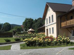 a house with a garden of flowers in front of it at Hajduk Apartment in Międzylesie