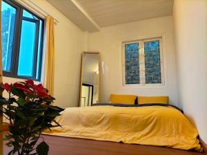 a bedroom with a bed with yellow sheets and a mirror at Chất home in Da Lat