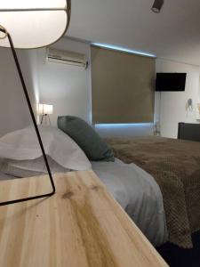 een slaapkamer met een bed en een tafel met een lamp bij Ubicación Premium! Departamento - PreViaje - Cuotas sin interés in Mendoza