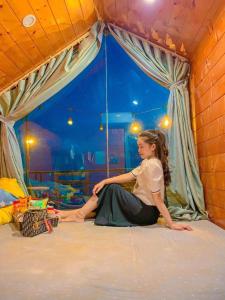 a woman sitting on the floor in a room at Tam Đảo Xanh Homestay - Venuestay in Vĩnh Phúc