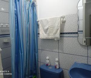 y baño con cortina de ducha azul y aseo. en Angello, en Lima