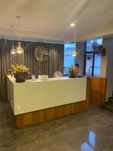 a lobby with a counter with potted plants on it at Luxe Inn in Kannur