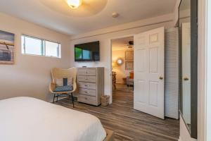 ein Schlafzimmer mit einem Bett, einem Stuhl und einer Kommode in der Unterkunft Delightful Cottage in Seaside Town of La Jolla Village in San Diego