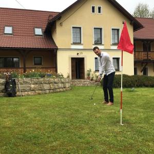 ミエンジレシエにあるHajduk Apartmentの庭でゴルフをしている男