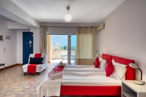 - une chambre avec un grand lit et une tête de lit rouge dans l'établissement Glyfa Corfu Apartments, à Barbati