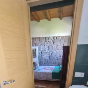 1 dormitorio con 1 cama en una pared de piedra en Torrebeatrice, en Bagnaia