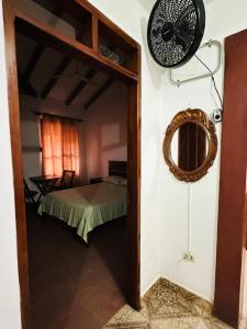 a room with a bed and a mirror and a fan at Departamento 2 habitaciones Trinidad Beni in Trinidad
