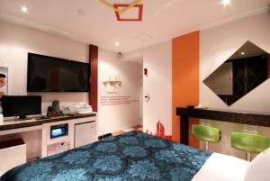 1 dormitorio con 1 cama y TV de pantalla plana en Jeonju Blue One, en Jeonju