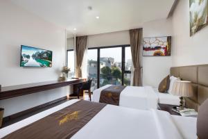 una camera d'albergo con due letti e una finestra di Diamond Luxury Hotel a Ha Long