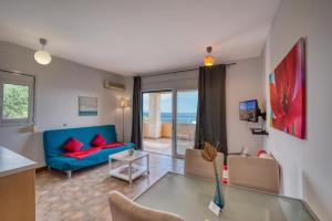 バルバティにあるGlyfa Corfu Apartmentsのリビングルーム(青いソファ、ガラスのテーブル付)