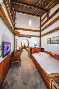 1 dormitorio con 1 cama y TV en una habitación en Hui Boutique hotel, en Huangshan