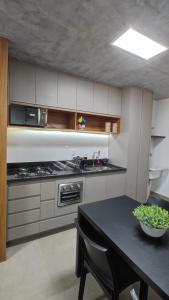 a kitchen with a table and a stove top oven at ID Vida Urbana Setor Oeste Goiânia 3703A in Goiânia