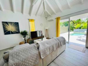 - un salon avec un canapé et une télévision dans l'établissement Villa Exotic Life récente avec piscine, 2 chambres, 2 SDB, à Le Moule