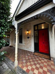 uma porta vermelha da frente de uma casa com uma porta vermelha em Villa on Melbourne St em Adelaide