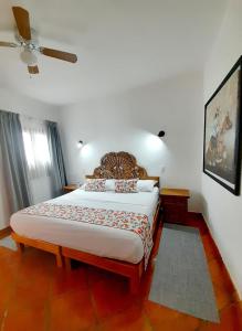 - une chambre avec un grand lit et un ventilateur de plafond dans l'établissement Hotel La Lejona, à San Miguel de Allende