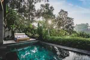 a house with a swimming pool in the middle of a garden at Amora Ubud Boutique Villas in Ubud