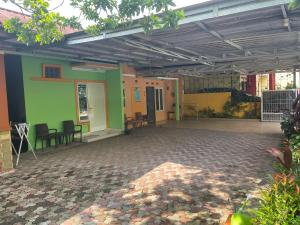 Cette chambre est dotée de murs, de tables et de chaises verts et colorés. dans l'établissement Bu Sur Homestay, à Bogor