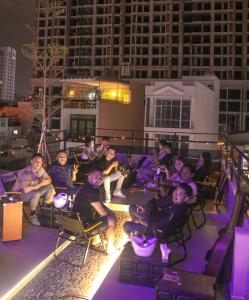 a group of people sitting on a rooftop at night at G9 Homestay - Đề Thám in Ho Chi Minh City