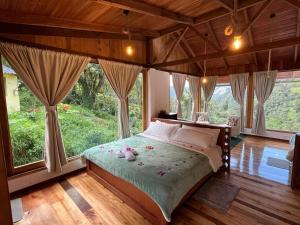 a bedroom with a bed in a room with large windows at La Casa de Martin in Baños