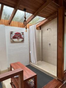 a bathroom with a shower and a bench and a table at La Casa de Martin in Baños