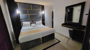 a bedroom with a large bed and a mirror at Palazzo Apartments in Ikeja