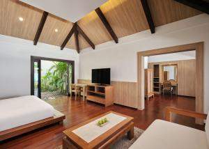 a bedroom with a bed and a desk and a tv at Garrya Tongsai Bay Samui in Choeng Mon Beach