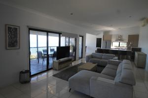 uma sala de estar com um sofá, uma mesa e uma cozinha em Moreton Magnificent Views em Tangalooma