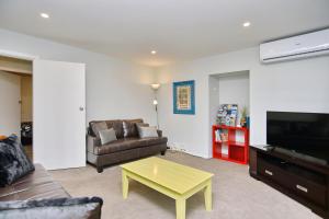 a living room with a couch and a coffee table at Charlesworth Villa - Christchurch Holiday Homes in Christchurch