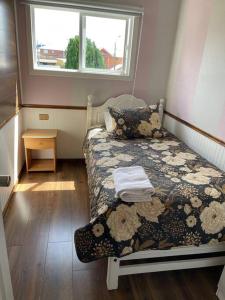 een kleine slaapkamer met een bed en een raam bij Departamento centro de Quellón in Quellón